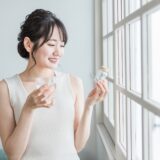 薬・サプリメント・ビタミン剤を飲む女性