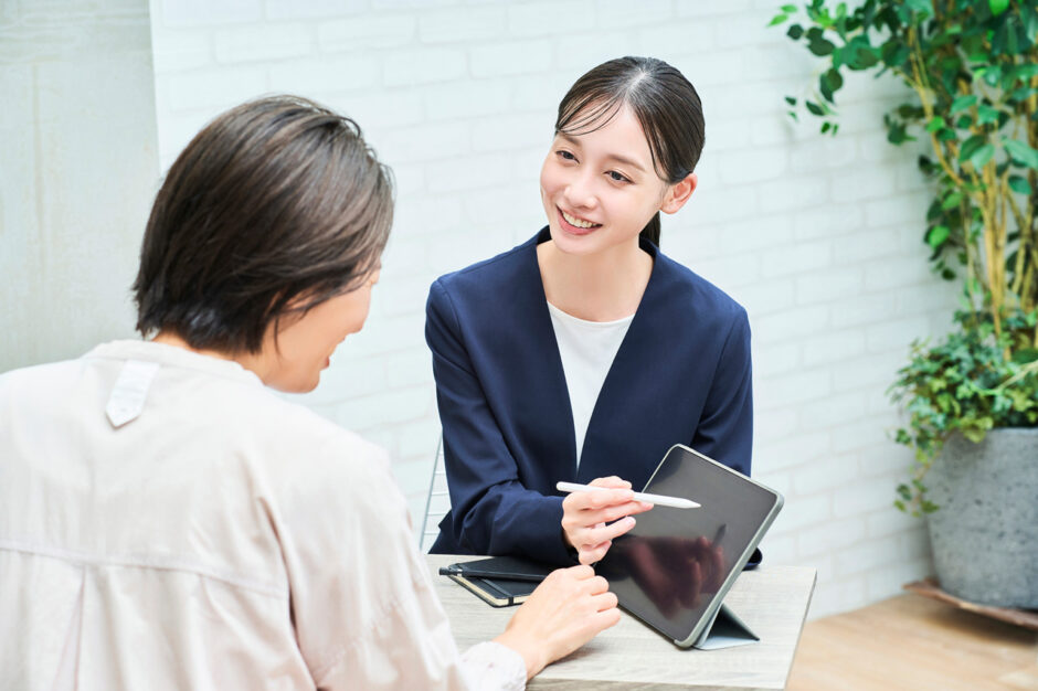 私服の女性に説明するスーツ姿の女性