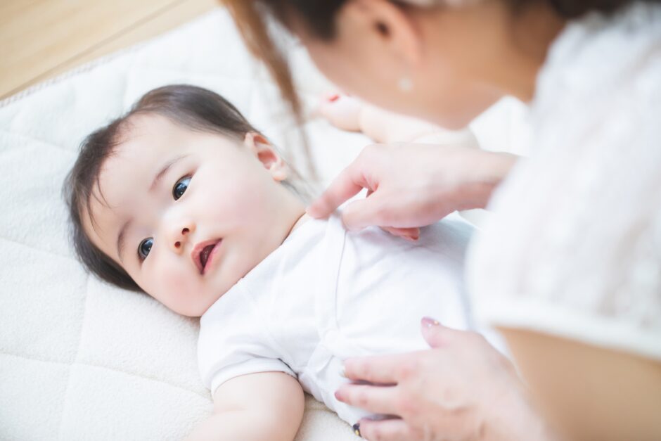 赤ちゃんを布団に寝かせる女性